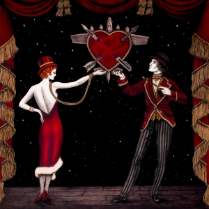 Theatrical scene with a man in a hat and red suit and a woman in a red gown dancing on a dark stage, a red heart with arrows centered behind them.